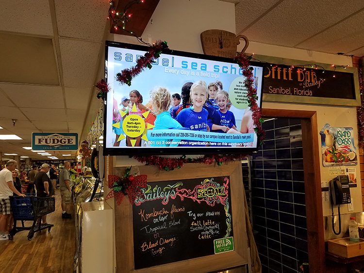 Digital advertising screen inside Bailey's General Store in Sanibel