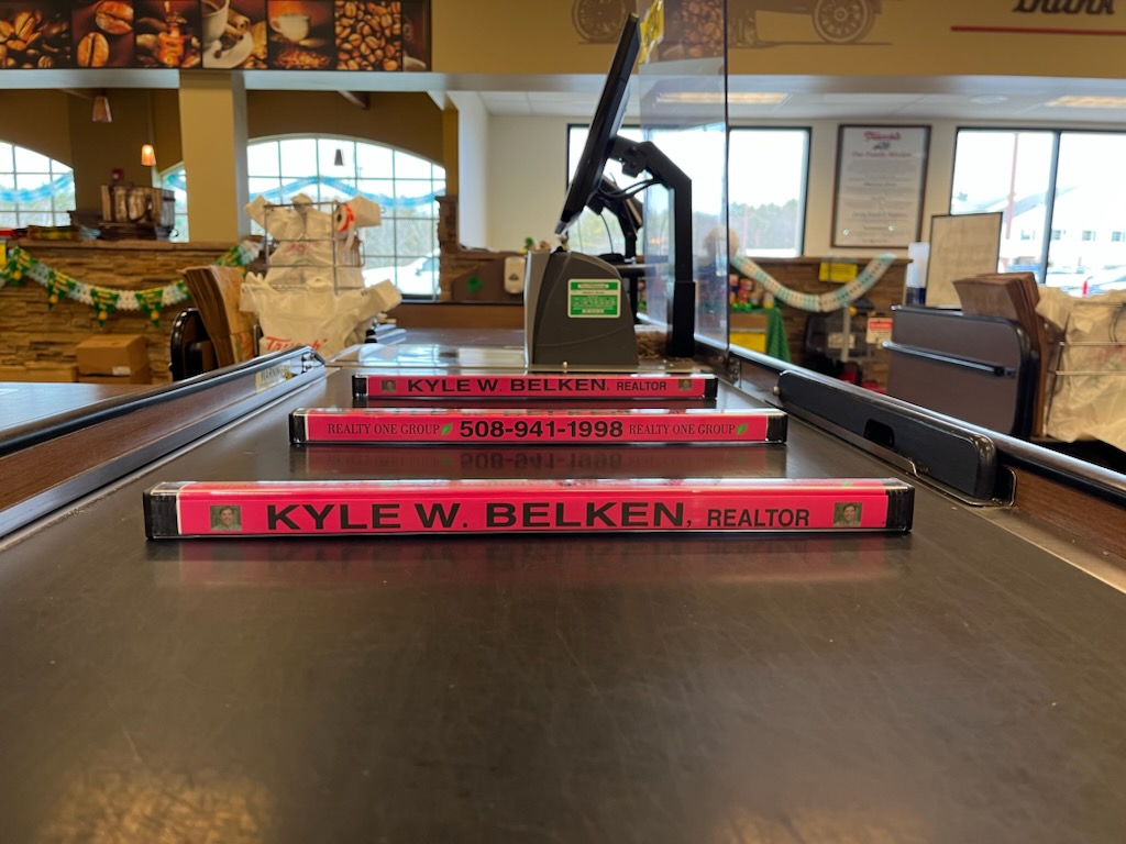 Kyle Belken branded dividers installed on a supermarket checkout belt