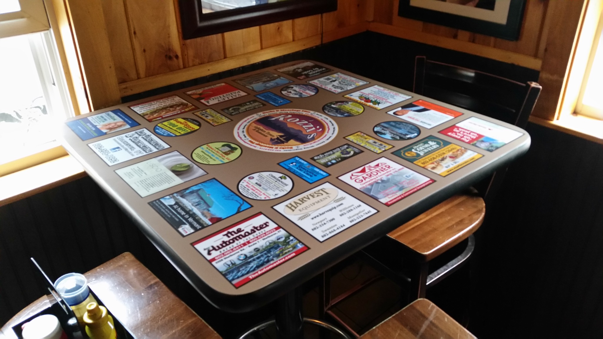 Installed square tabletop featuring local business advertisements